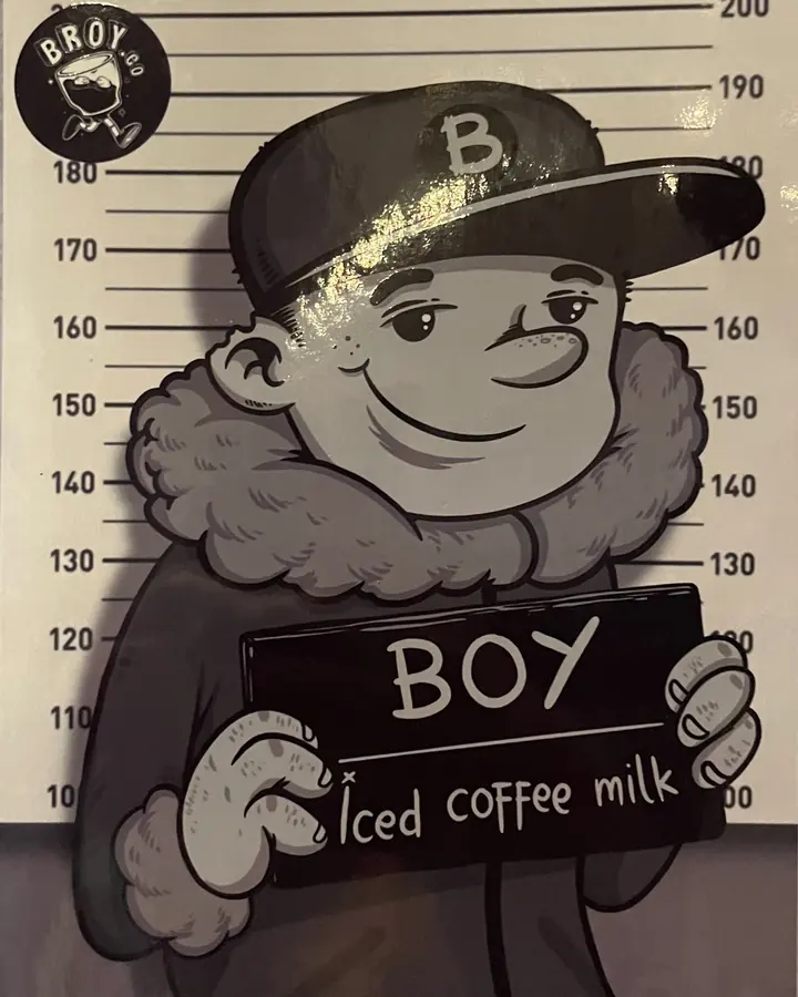 Poster karakter Boy bertopi huruf B dengan papan bertuliskan Iced coffee milk